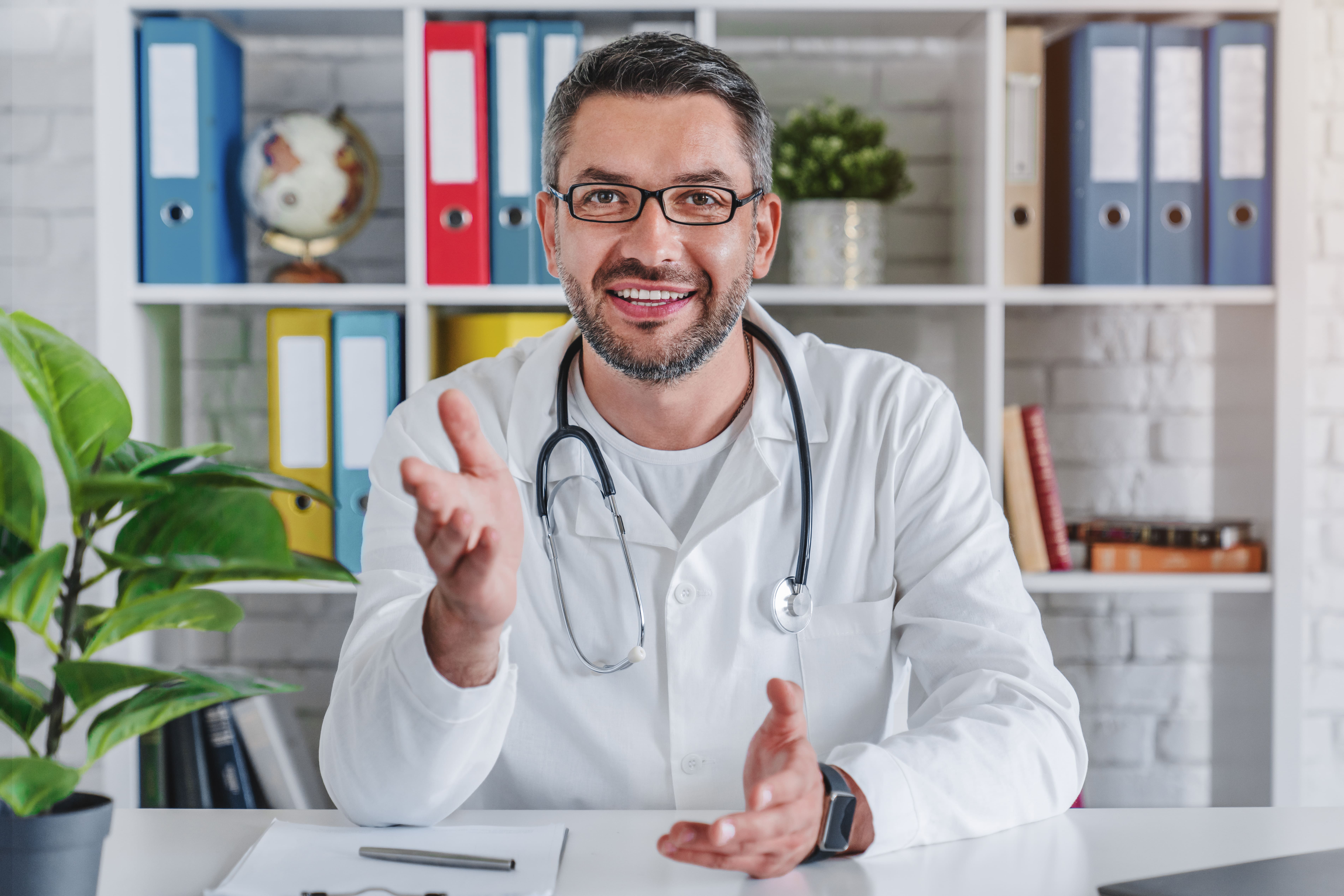 Senior-doctor-talking-to-camera-in-video-chat-from-his-office-1253833610_7612x5077 (2)-2